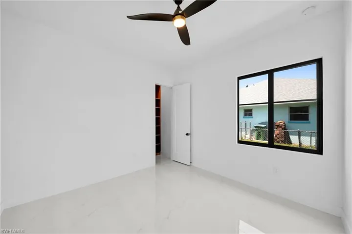 Empty room featuring ceiling fan and tile patterned flooring