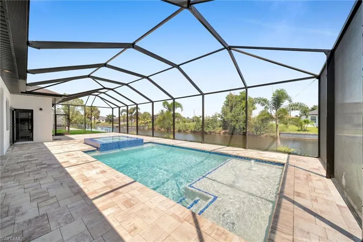 View of pool with a patio area, an in ground hot tub, and a lanai