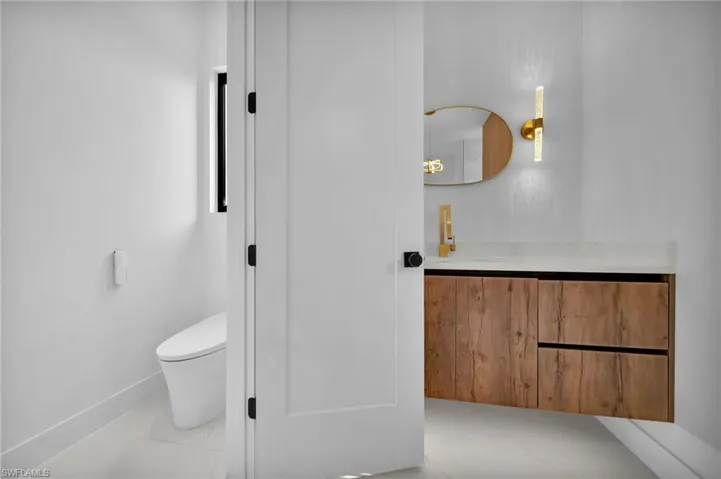 Bathroom featuring toilet, vanity, and tile patterned floors