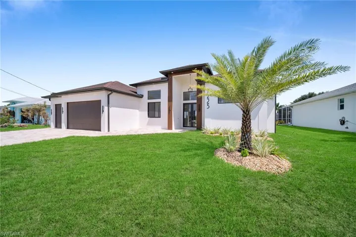 View of front of home featuring a front yard and a garage