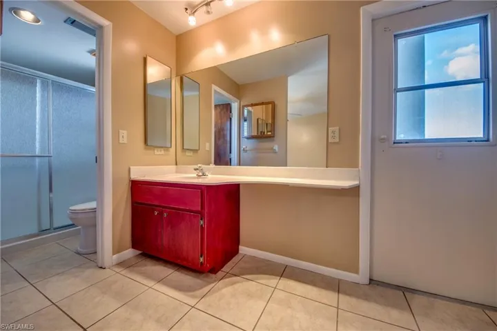 Bathroom with vanity, toilet, a shower with door, and tile patterned floors