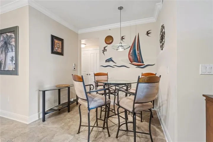 Dining space featuring ornamental molding and light tile patterned floors