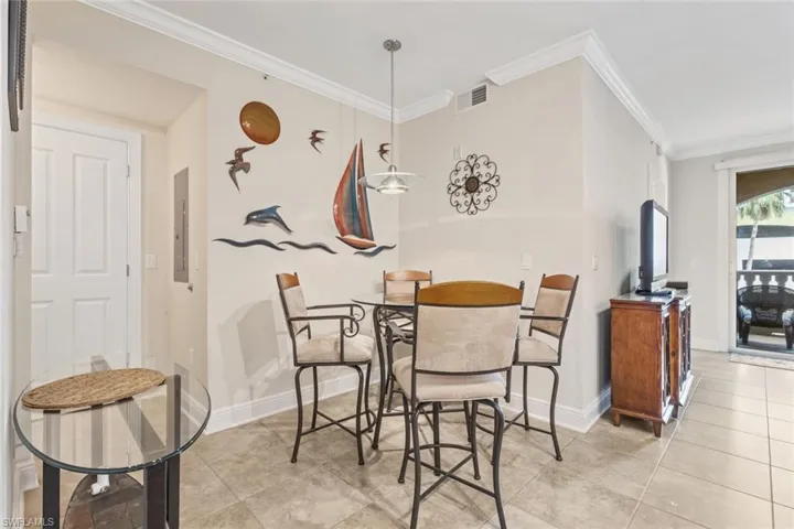 Dining room featuring ornamental molding and light tile patterned floors