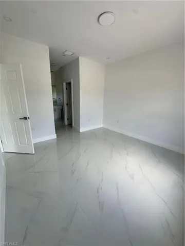 Spare room with baseboards and light marble finish flooring