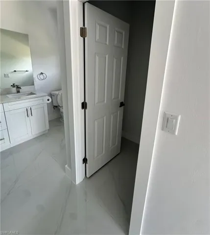 Bathroom with vanity and marble look tiles