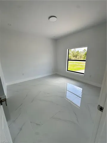 Spare room with marble finish flooring and baseboards