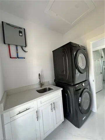Washroom with stacked washer / dryer and cabinet space
