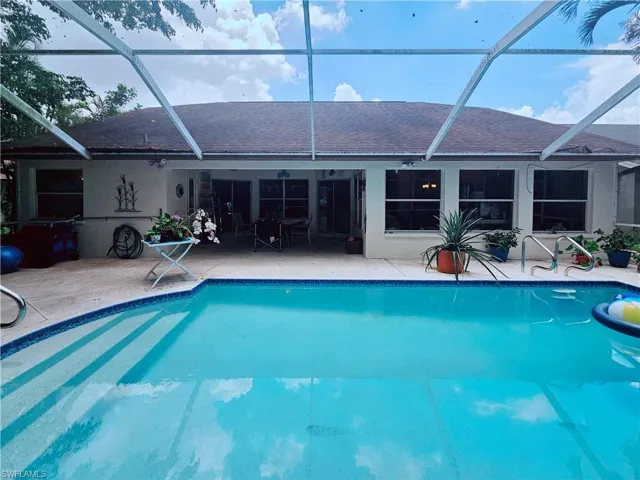 Outdoor pool with a patio area and glass enclosure
