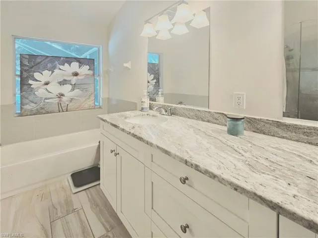 Full bath featuring vanity and a garden tub