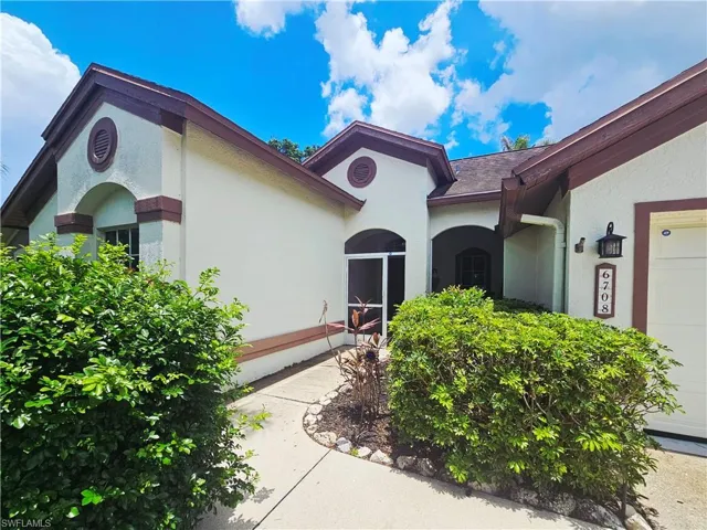 View of exterior entry featuring stucco siding and an attached garage
