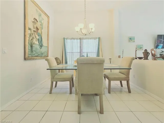 Dining room with a chandelier and light tile patterned floors