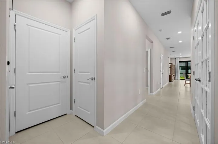 Hall with recessed lighting and light tile patterned floors