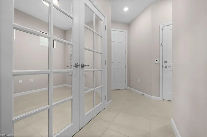 Hall featuring baseboards and light tile patterned floors