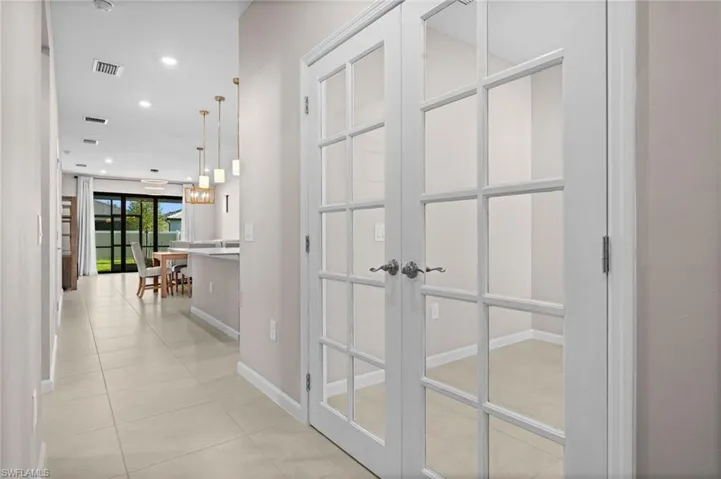 Hallway featuring recessed lighting, light tile patterned floors, and french doors