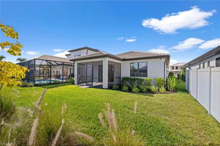 Rear view of property featuring a sunroom, a tiled roof, a lanai, an outdoor pool, and stucco siding