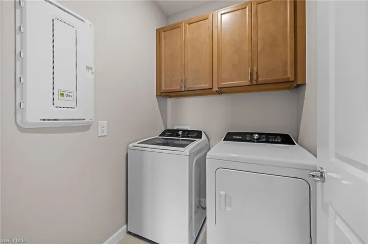 Laundry room with cabinet space, washer and dryer, and electric panel