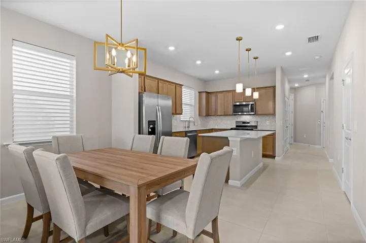 Dining room featuring a chandelier, light tile patterned floors, and recessed lighting