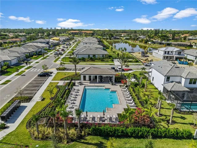 Aerial view of residential area with a pool area and a large body of water