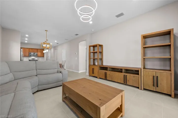 Living area with recessed lighting, a chandelier, and light tile patterned flooring