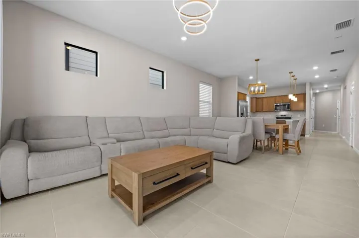 Living room with a chandelier, recessed lighting, and light tile patterned floors
