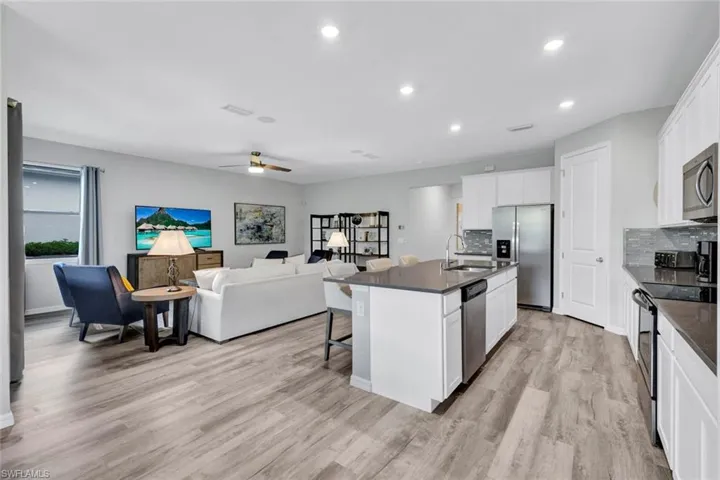 Open-concept living space featuring wood-finish flooring, recessed lighting, and a ceiling fan