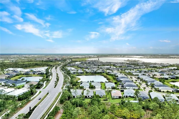 Expansive aerial view showcasing a planned community with diverse residential properties, numerous water features, and significant natural landscaping