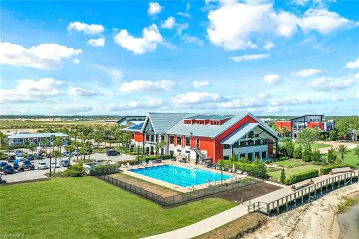 Community clubhouse featuring a lap pool, extensive green spaces, and a boardwalk