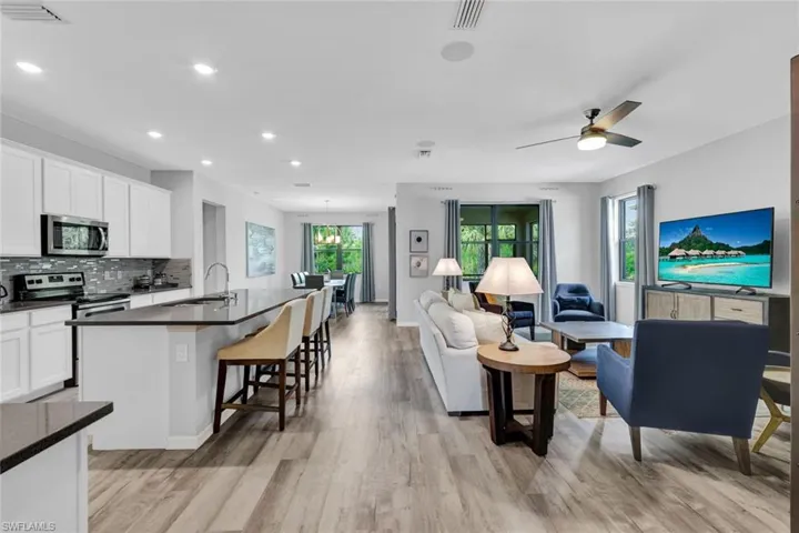 Open-concept living space featuring wood-finish flooring, recessed lighting, and a ceiling fan