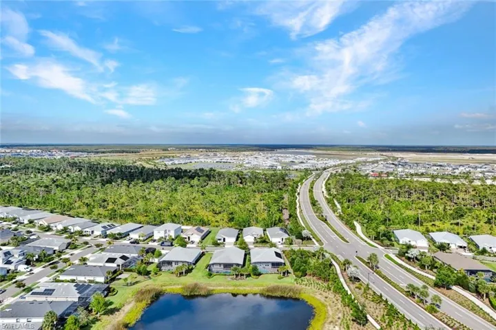 Aerial perspective showcasing a residential community with numerous homes featuring solar panels
