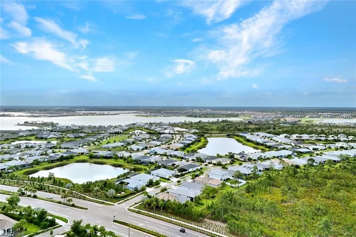Expansive community featuring numerous single-family residences with a water backdrop