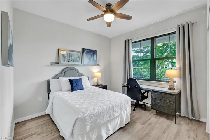 Light wood-finish flooring complemented by a window-mounted desk with dark cabinetry