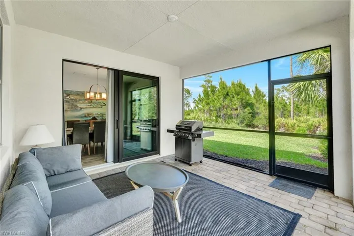 Screened patio featuring paver flooring, a white textured ceiling, and a large sliding glass door