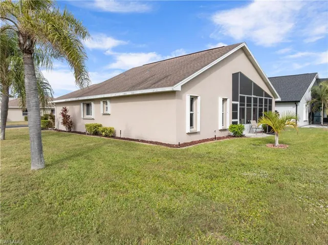View of home's exterior with a lawn and a sunroom