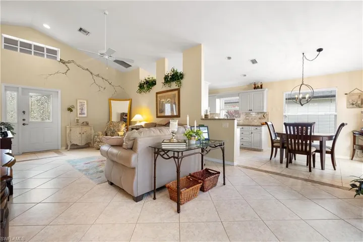 Living room featuring ceiling fan, light tile patterned floors, and a wealth of natural light