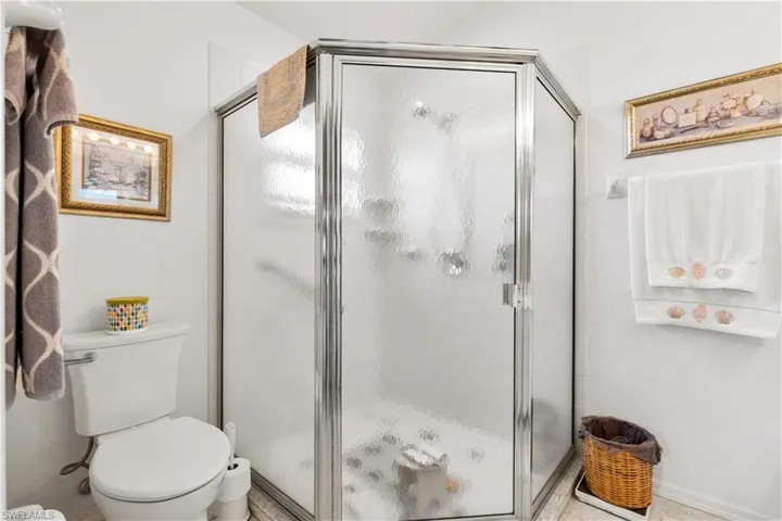 Bathroom featuring toilet and a shower with door