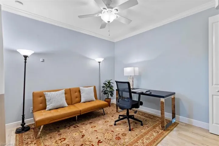 Home office with ornamental molding, ceiling fan, and light wood-type flooring