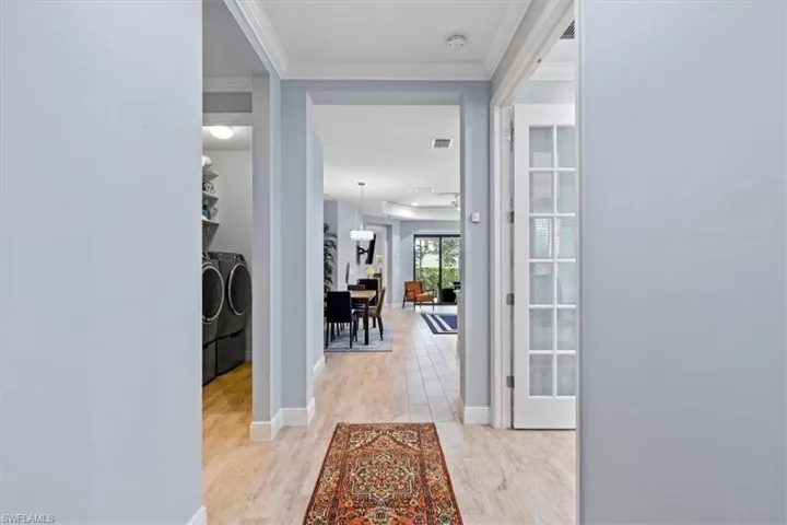 Corridor with light wood-type flooring, and ornamental molding