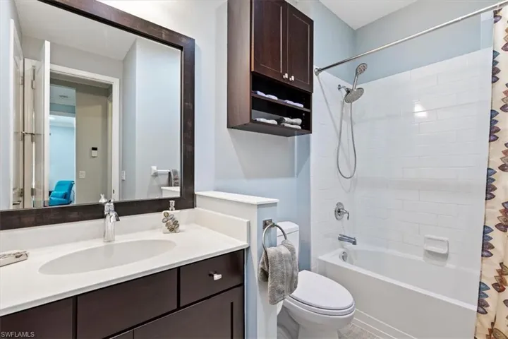 Full bathroom with toilet, vanity, and shower / tub combo