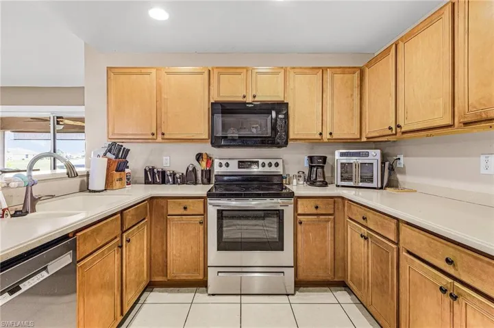 Kitchen featuring stainless steel appliances, light tile patterned floors, light countertops, and recessed lighting