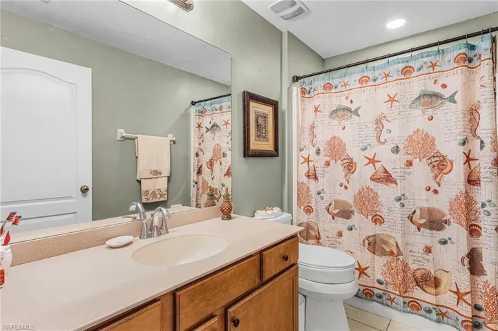 Full bathroom featuring vanity, tile patterned flooring, and curtained shower