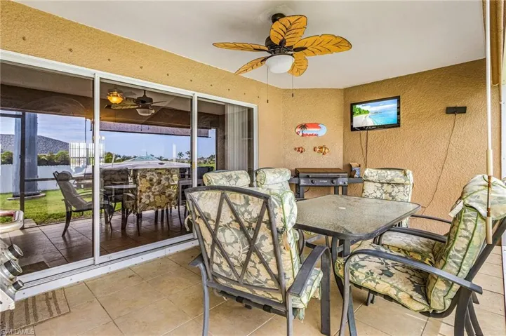 Sunroom / solarium featuring outdoor dining space, ceiling fan, and healthy amount of natural light