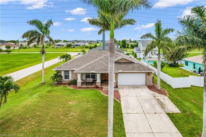 Ranch-style home featuring a garage, concrete driveway, stucco siding, a residential view, and a porch
