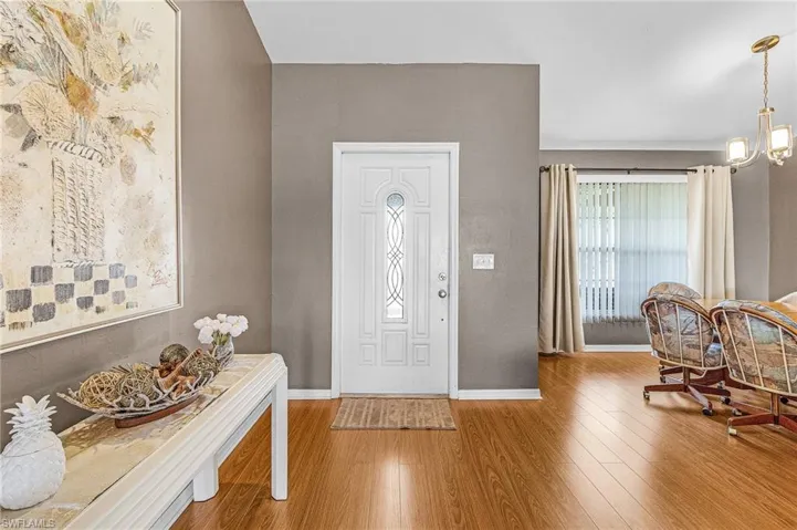 Entryway featuring wood finished floors and a chandelier