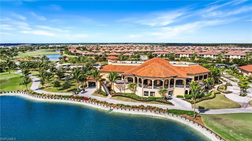 Aerial view of residential area featuring a nearby body of water and a golf club