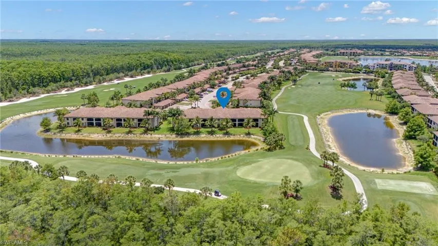 Aerial view of property's location featuring a large body of water, a golf course, and a forest