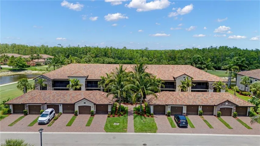 Multi unit property featuring a tile roof, a water view, community garages, and stucco siding