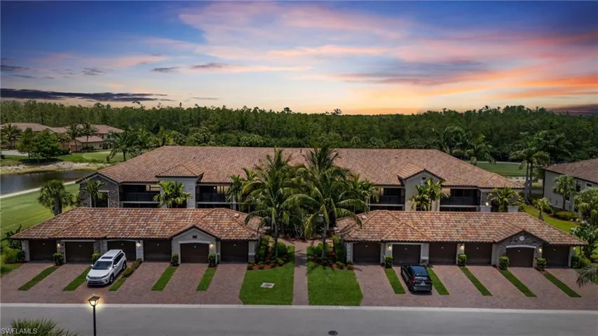 View of front of home with a tile roof, driveway, and a water view
