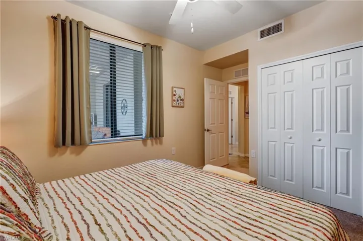 Carpeted bedroom with a closet and a ceiling fan
