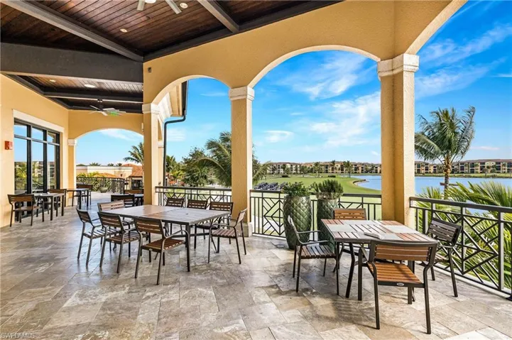 View of patio / terrace featuring outdoor dining space, ceiling fan, a water view, and fence