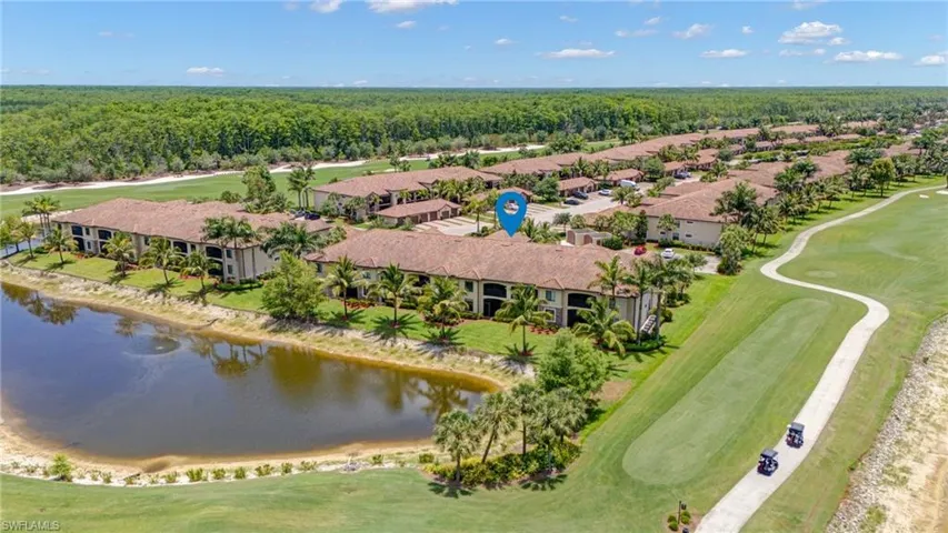 Drone / aerial view of a nearby body of water, a local golf course, and a forest